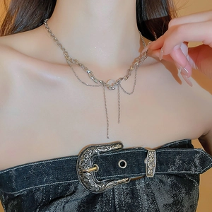 Detail of silver star necklace with tassel chain and gemstone pendant on a model