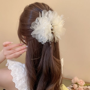 Detail of elegant white organza flower hair claw with delicate pearls and gold metal clip