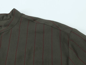 Detail of the stand collar and red stripes on dark olive green casual shirt fabric