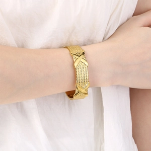 18K gold plated wide textured bangle with bold X-shaped crossover design on wrist