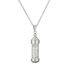 Détail macro du pendentif bouteille de parfum en acier argenté rempli de pierres blanches