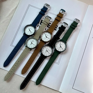 Flat lay of multiple minimalist quartz watches with various colored fabric straps