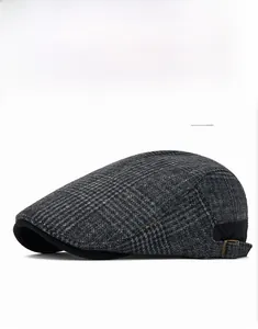 Close-up of gray plaid wool flat cap with side buckle and thick warm texture detail