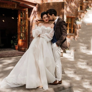 Elegante abito da sposa bianco con maniche in tulle a pois e scollatura a cuore bardot