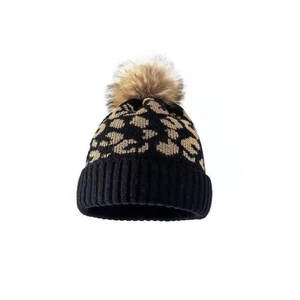 Winter leopard print knit beanie for women with a fluffy brown faux fur pom pom decoration