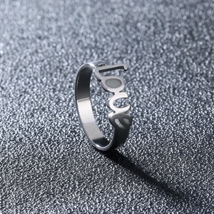 Macro detail of silver stainless steel ring featuring hollowed out love letter design