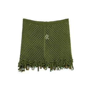 Detail of green mesh knit beach skirt with tassel hem and colorful bead accents