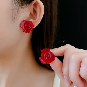 Gros plan de boucles d'oreilles roses rouges en résine aux détails de fleurs brillants