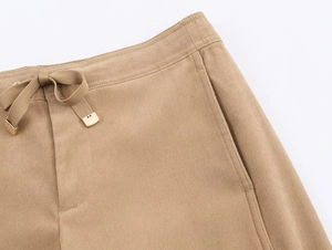 Détail du pantalon kaki avec taille élastique, cordon de serrage et embouts métalliques