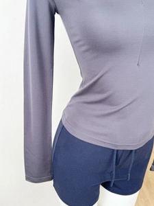Detailed close-up of grey-purple slim fit long sleeve top and navy drawstring shorts