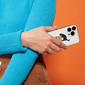 Close-up of waterproof black cat book sticker on a phone back with orange background