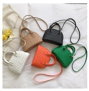 Flat lay of quilted shell bags in white, brown, black, orange and green with V-stitching