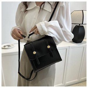 Détail d'un cartable en cuir PU noir montrant la boucle dorée et le rabat rectangulaire