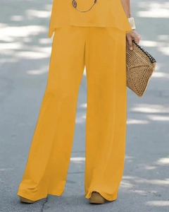 Détail d'un haut sans manches jaune et d'un pantalon large taille haute sur un mannequin