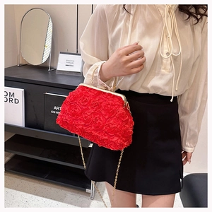 Detail of red 3D rose fabric clutch bag with elegant golden chain and crystal clasp