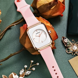 Detail of pink silicone strap and rose gold square quartz watch with brand logo dial