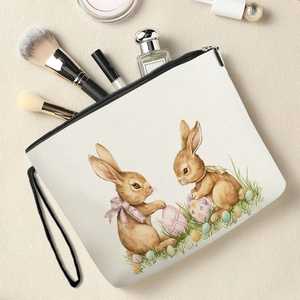 Floral bunny canvas makeup bag with zipper and wrist strap on a textured surface