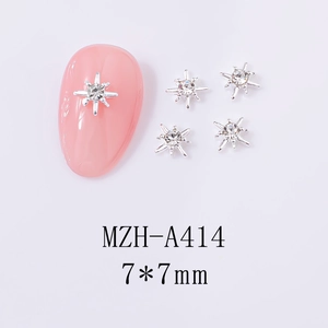 Macro detail of 7x7mm silver star nail charms with crystal rhinestones on pink nails