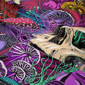 Close-up of bohemian tapestry fabric showing psychedelic skull and mushroom patterns