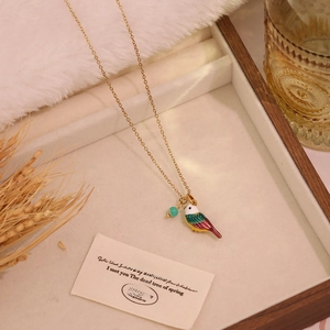 Gold titanium steel necklace featuring a colorful enamel bird pendant and turquoise bead