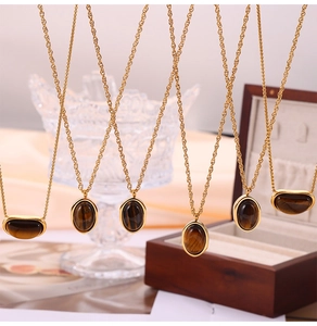 Vue détaillée de pendentifs œil-de-tigre sur chaînes en titane doré au style vintage