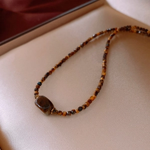 Detail of tiger eye beaded necklace with faceted brown stones and a center rectangular bead