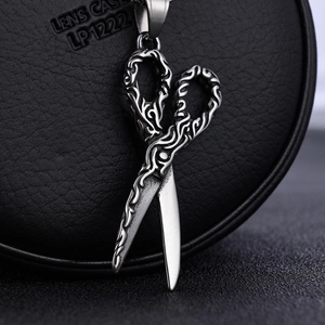 Macro view of stainless steel scissor pendant with detailed gothic texture carvings