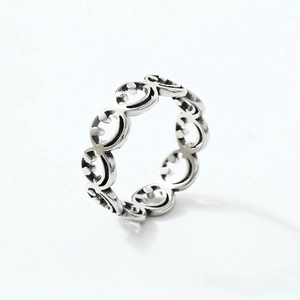 Polished stainless steel ring featuring a laser-cut hollow smiley face pattern