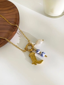 Detailed close-up of golden boot charm, pearl and blue-white porcelain beads on a chain