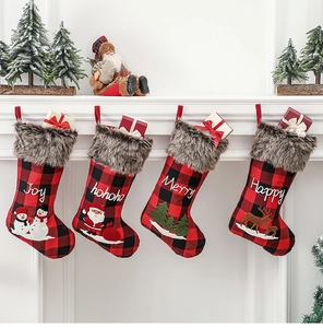 Détail de quatre chaussettes de Noël à carreaux avec bordure en peluche sur une cheminée