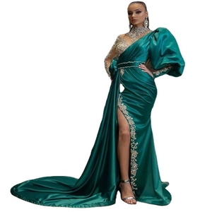 Detail of dark green satin evening dress featuring silver diamond embroidery and high slit
