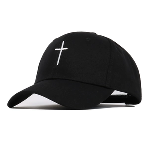 Detail showing white cross embroidery on the front of a black cotton baseball cap