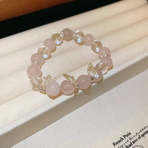 Détails de perles en cristal rose et breloques papillon en argent sur le bracelet