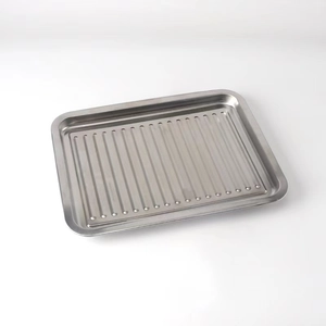 Close-up of a rectangular stainless steel grill pan with drainage holes for outdoor BBQ