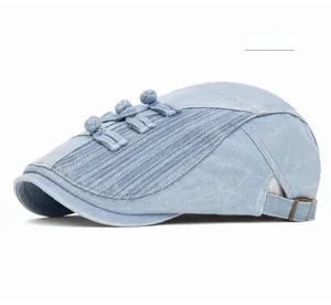 Detail of light blue denim flat cap with traditional Chinese knots and metal buckle