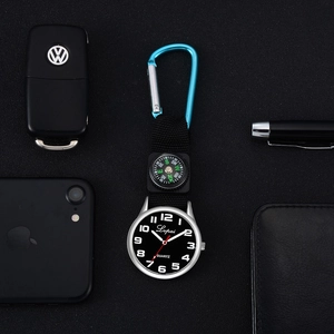 Multi-function quartz pocket watch with blue carabiner, compass and woven strap on a dark desk