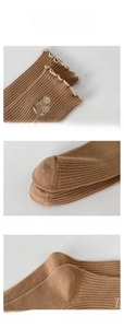 Detail display of brown ribbed cotton socks featuring floral embroidery and reinforced toes