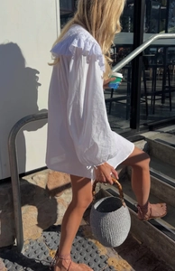 Detail der weißen Bluse mit Rüschen-Spitzenkragen und langen Laternenärmeln im Sonnenlicht