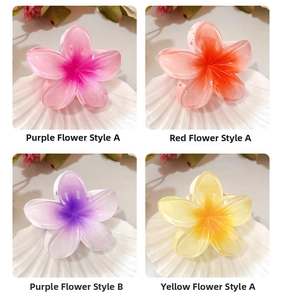 Détail de quatre pinces à cheveux en forme de fleurs aux couleurs pastel dégradées