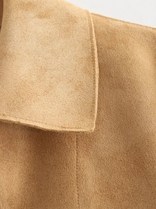 Macro shot of camel faux suede fabric with precise double-stitching details on the jacket