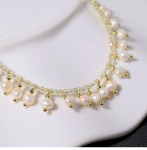 Detail of natural freshwater pearls and gold metal beads on a minimalist necklace