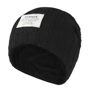 Black cable knit beanie hat with white textile patch for men and women