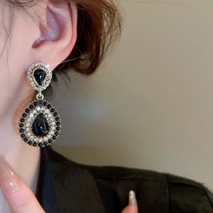 Detail of vintage drop earrings with black teardrop stones and sparkling zircon pavé