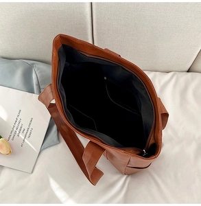 Top view of brown PU tote bag showing internal zipper pocket and spacious lining detail