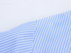 Close-up macro of blue and white striped shirt fabric showing fine texture and sewing