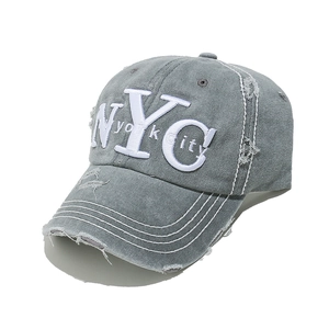 Detail of vintage washed grey canvas baseball cap with NYC embroidery and distressed holes