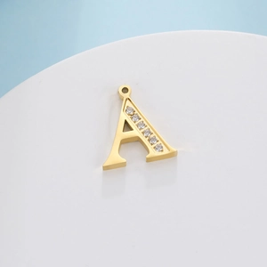Macro detail of a gold letter A pendant featuring small sparkling inlaid round crystals