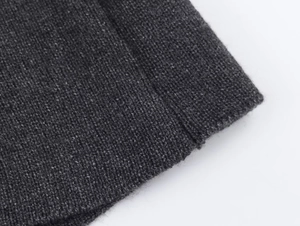 Gros plan sur la texture en tricot gris anthracite et les coutures de la robe