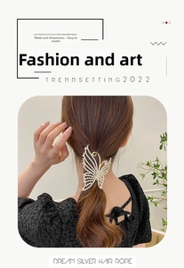 Detailed view of a golden butterfly hair claw with rhinestone tassels on model's hair