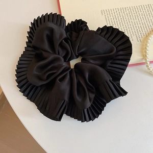 Gros plan du chouchou en satin noir plissé avec des détails de texture française